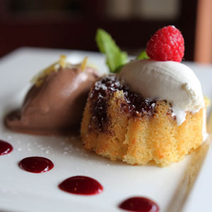 pound cake topped with vanilla ice cream and raspberry, drizzled with raspberry sauce, garnished with mint