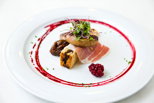 elegantly-plated close-up of four oysters rockefeller with bread crumbs