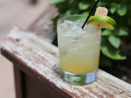 a lemon-based cocktail garnished with lime slime and candied ginger